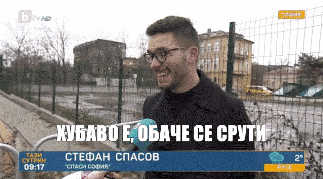 a man wearing glasses is smiling in front of a fence while being interviewed on a tv channel