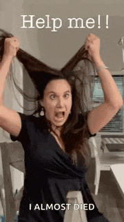 a woman in a black dress is holding her hair up in the air .