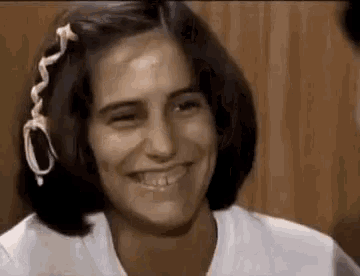 a woman with a braid in her hair is smiling .