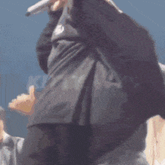 a man is singing into a microphone while wearing a black shirt that says ' abercrombie & fitch ' on it