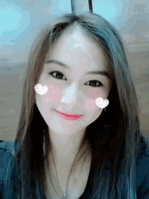 a woman with a heart on her cheek smiles for the camera