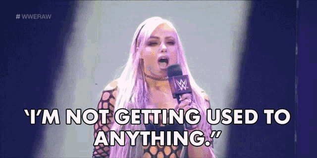 a woman speaking into a microphone with the words " i 'm not getting used to anything "