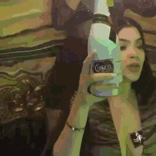 a woman holding a bottle of caskco in her hand