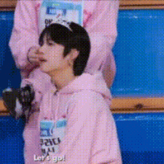 a man in a pink hoodie is standing next to a woman in a pink hoodie .