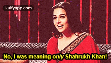 a woman in a red saree is smiling and says no i was meaning only shahrukh khan