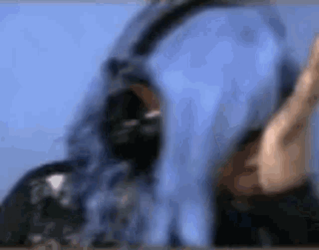 a woman with blue hair is wearing headphones on her head .
