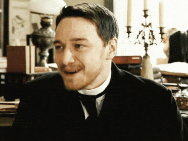 a man with a beard wearing a black suit and tie
