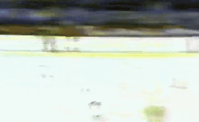 a blurry picture of a hockey game with a goalie and a player