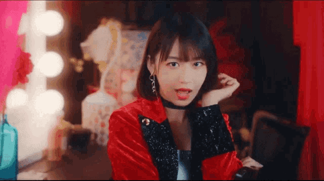 a woman in a red jacket with a choker on her neck