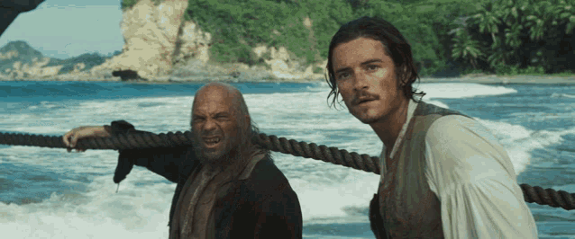 two men standing next to each other in the water