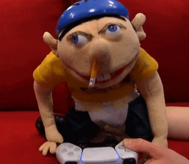 a puppet with a pencil in his mouth is playing a video game with a controller