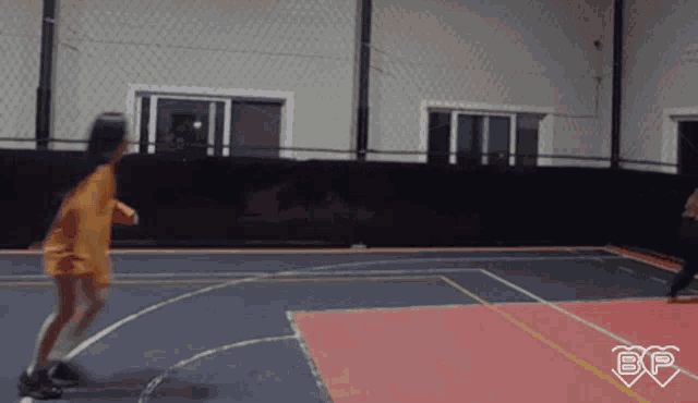 a girl is jumping a rope on a basketball court with the letter bp in the corner
