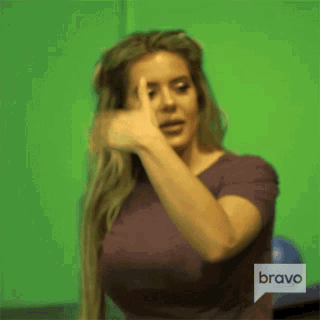a woman in a purple shirt with a bravo logo on the bottom right