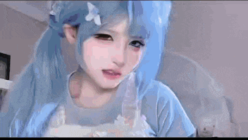 a close up of a girl with blue hair and a cat ears .