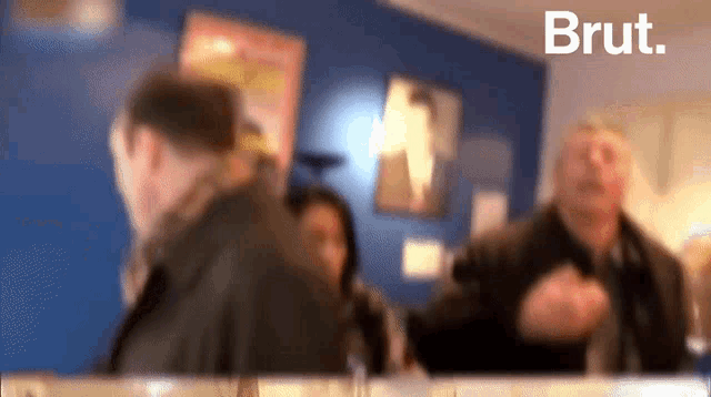 a blurred image of a group of people with the word brut in the corner