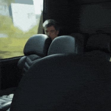 a man is sitting in a bus looking out the window