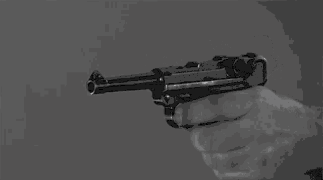 a black and white photo of a person holding a gun in their hand