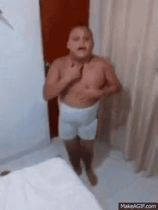 a shirtless man in white underwear is standing in a bedroom .
