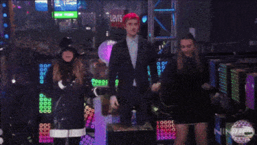 a crowd of people are gathered in a dark room with a sign that says oh call me yes !
