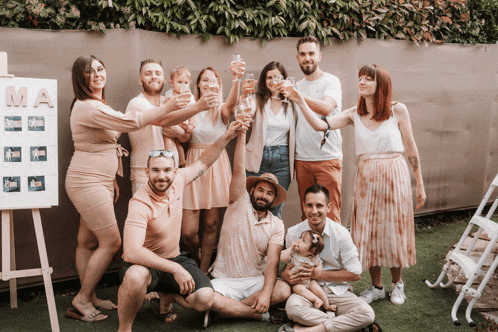 a group of people toasting in front of a sign with the letter ma on it