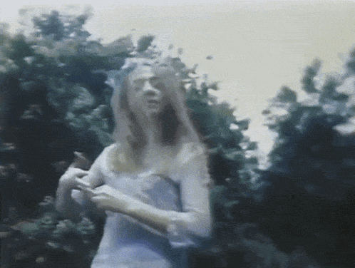 a blurry painting of a woman in a white dress with trees in the background