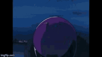 a purple helmet is sitting on top of a table in front of a city at night .
