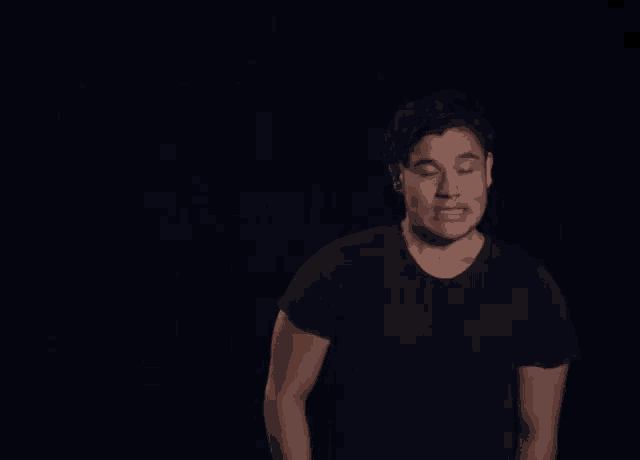 a man in a black shirt is standing in front of a black background that says alright
