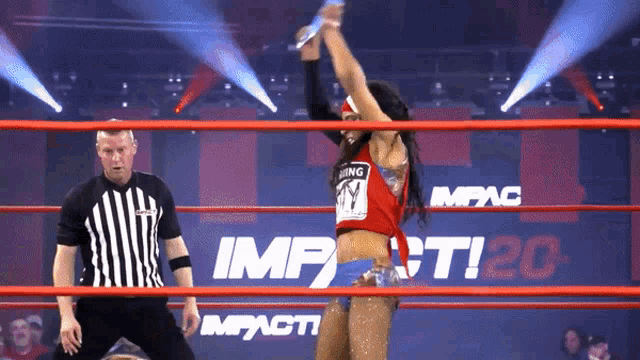 a woman in a wrestling ring with impact 20 on the wall