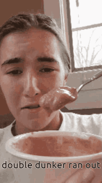 a woman is eating a spoonful of food with the caption double dunker ran out