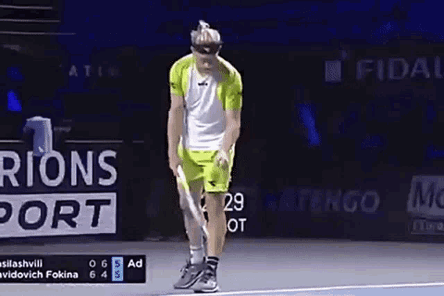 a man is holding a tennis racquet on a tennis court in front of an ad for rions port