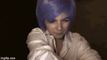 a woman with purple hair and a white shirt is smiling