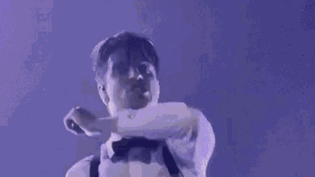 a man in a tuxedo is holding a large knife in his mouth .