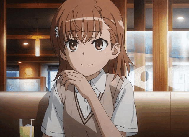 a girl with brown hair and a white shirt is sitting in a restaurant