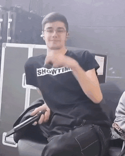 a man wearing a showtime t-shirt is holding a microphone