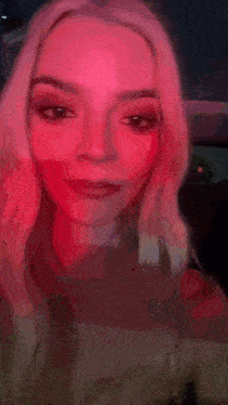 a woman is smiling in the back seat of a car at night