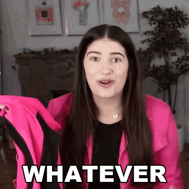 a woman in a pink jacket is holding a jacket and says whatever