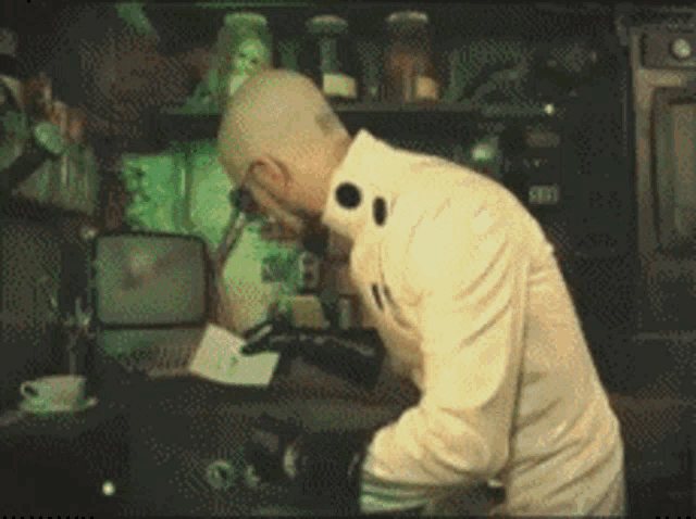 a man in a lab coat is looking through a microscope at something