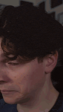 a close up of a man 's face with a denim jacket on