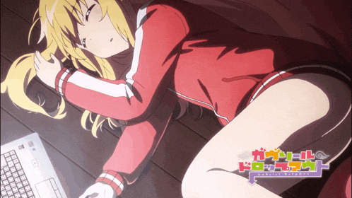 a girl in a red jacket is laying on the floor next to a laptop computer