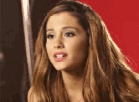 a woman with long brown hair is looking at the camera