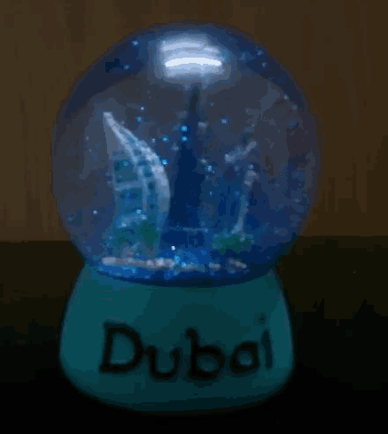 a dubai snow globe with a sailboat inside