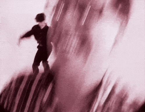 a blurry picture of a person standing on top of a red object .