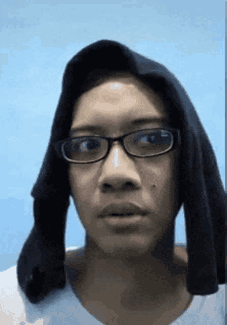 a woman wearing glasses and a black hoodie looks at the camera with a surprised look on her face