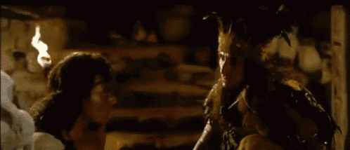a man with feathers on his head is standing next to a woman