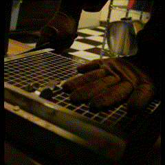 a pair of brown gloves are sitting on a wire rack in a kitchen