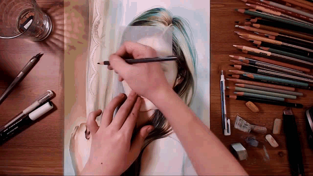 a person is drawing a woman 's face with a pencil on a piece of paper