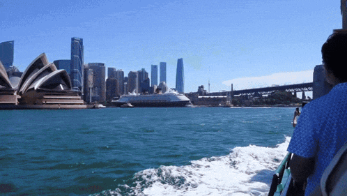 the sydney opera house is visible in the distance from a boat