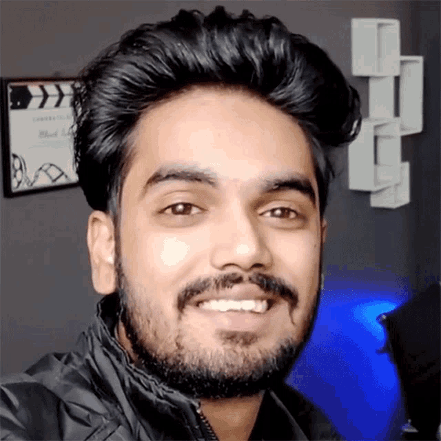 a man with a beard is smiling for a picture