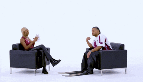 a man and a woman are sitting in chairs with their legs crossed