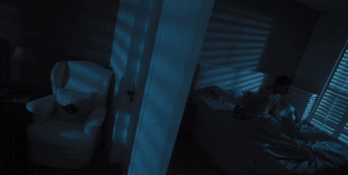 a person laying on a bed with a chair in the background